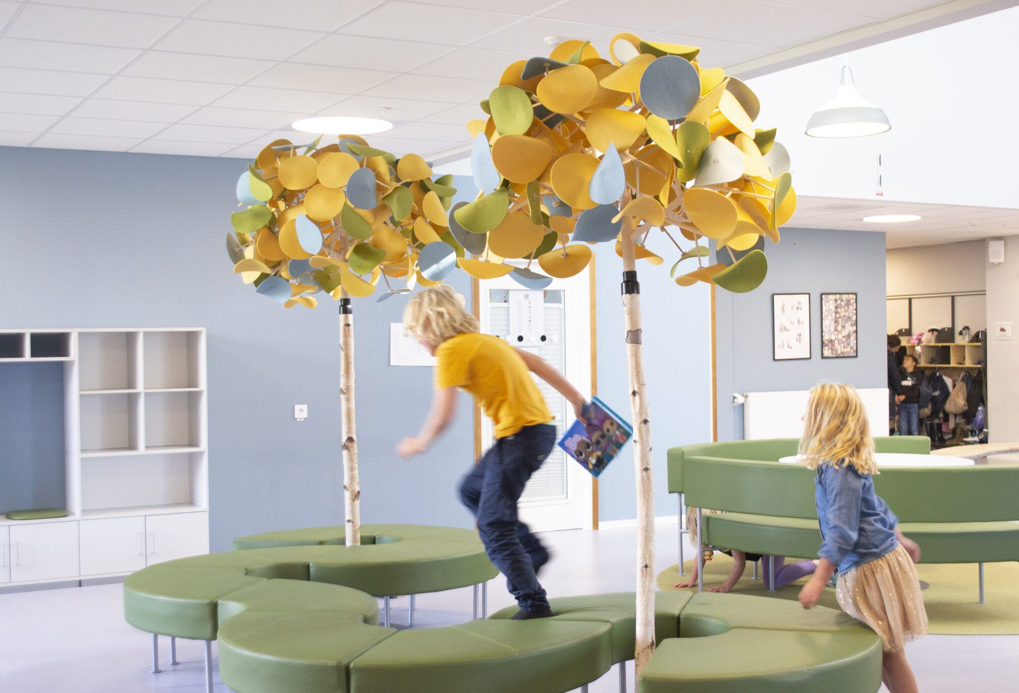 Leerlingen spelen onder Leaf Lamp-bomen in een school in Staffanstorp